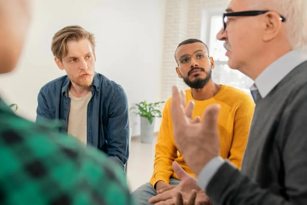 Men participating in group therapy, building connection and support during addiction recovery.