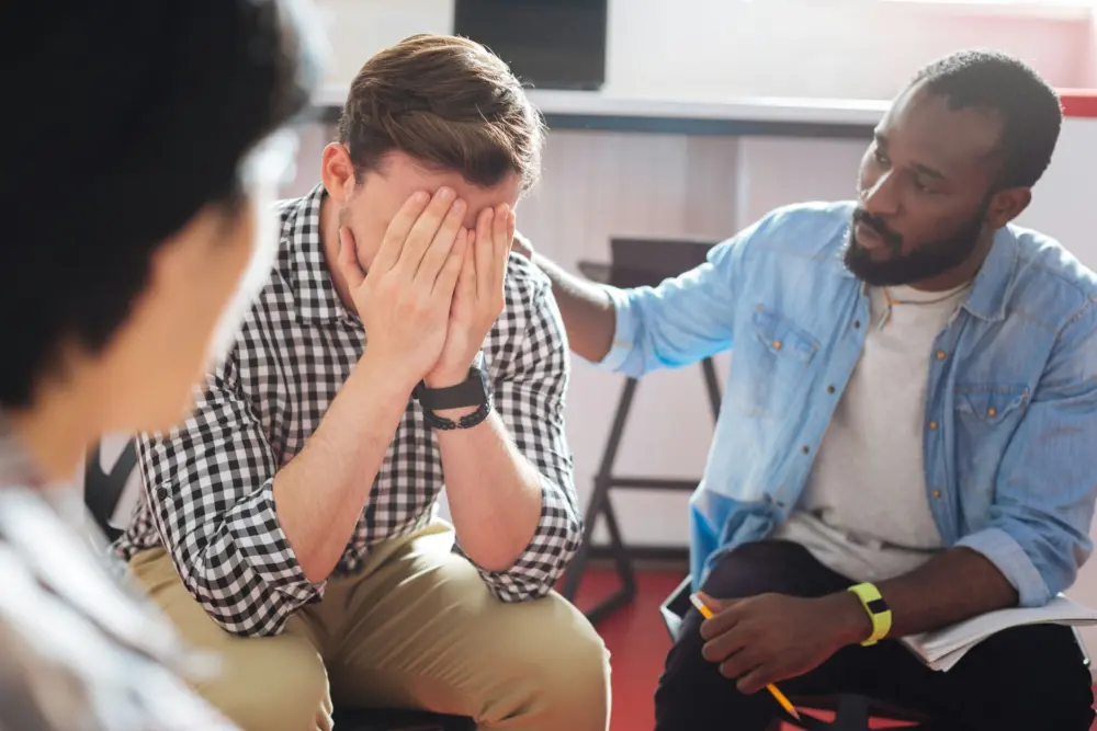 man in group therapy experiencing emotional highs and lows linked to sports outcomes and gambling behaviors.