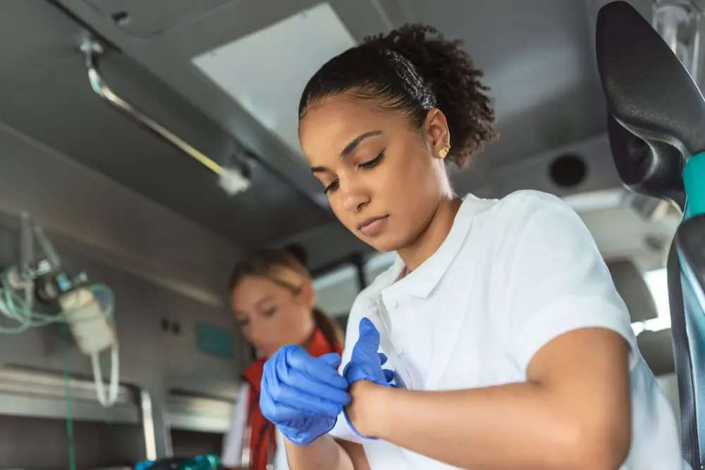a-paramedic-putting-on-gloves-to-help-a-patient