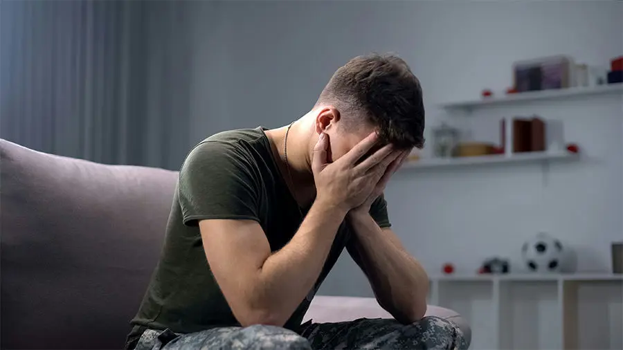 a-veteran-with-ptsd-with-hands-on-face-in-therapy
