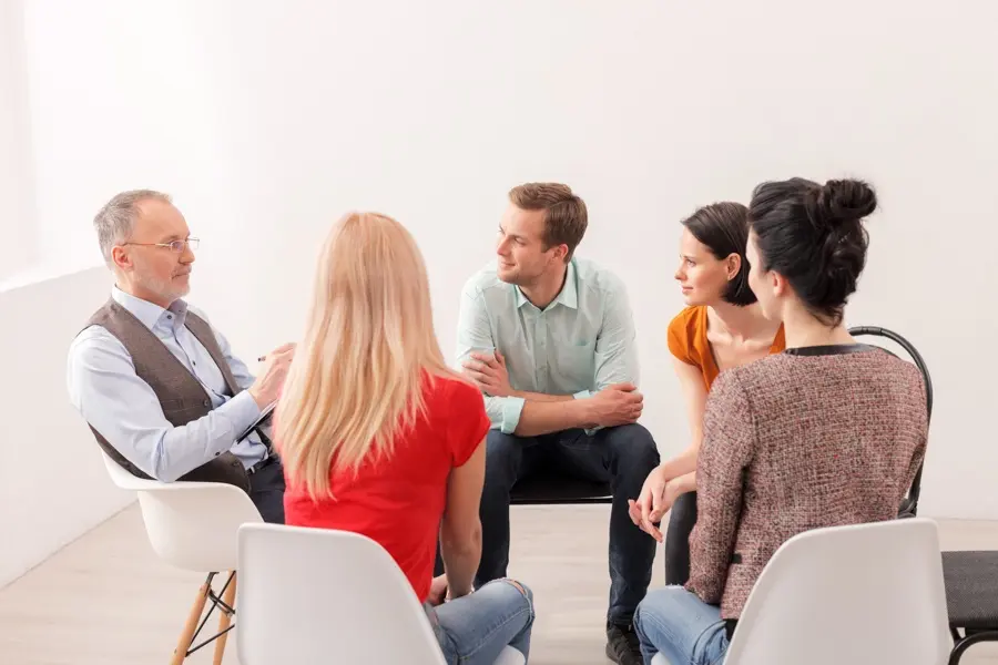 a-group-of-individuals-in-therapy-talking-to-therapist