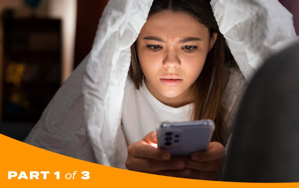 Young girl in bed browsing social media on her phone