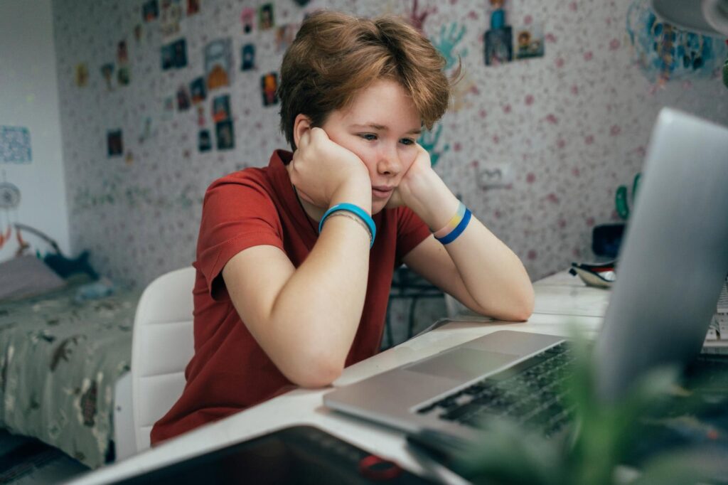 Teen looking stressed at computer.