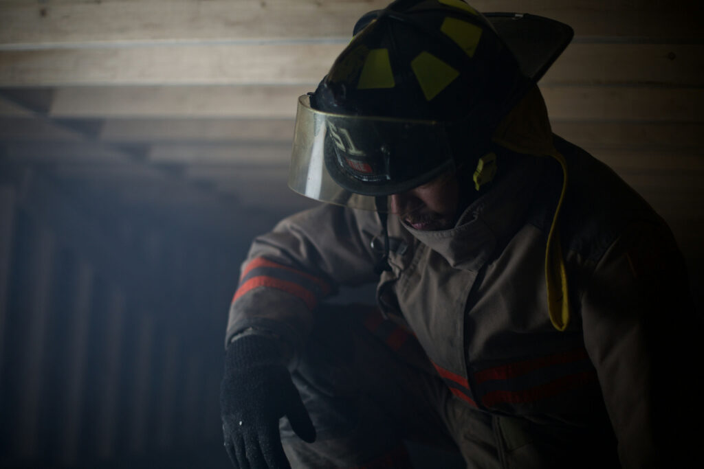 First responder sitting alone after a shift reflecting on trauma exposure and mental health stress