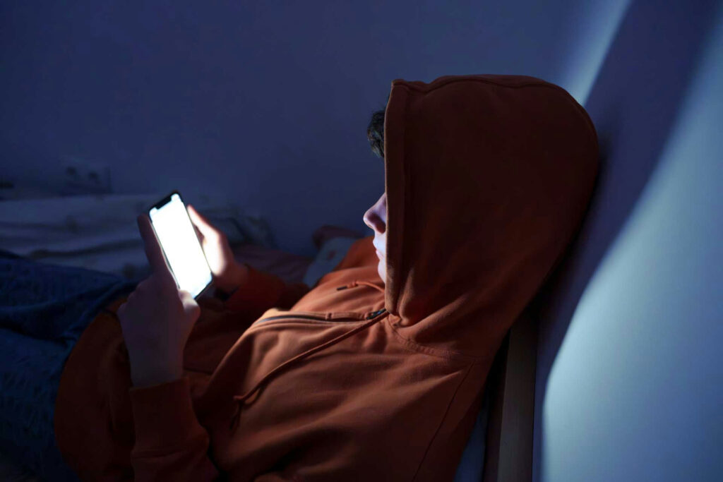 Teen sitting alone looking stressed and isolated in bedroom